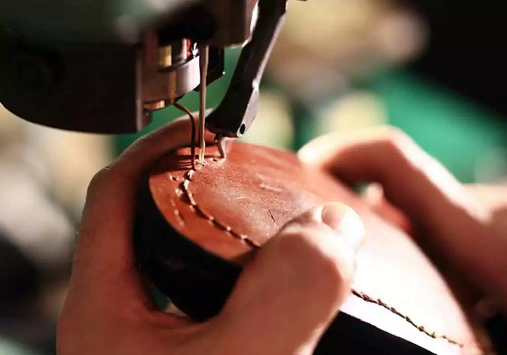 alt "Willkommen Schuhtechnik - Eine Sohle wird mit der Maschine genäht"